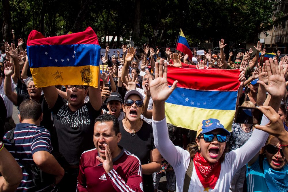 Manifestantes gritan consignas frente a integrantes de la Guardia Nacional Bolivariana (GNB).