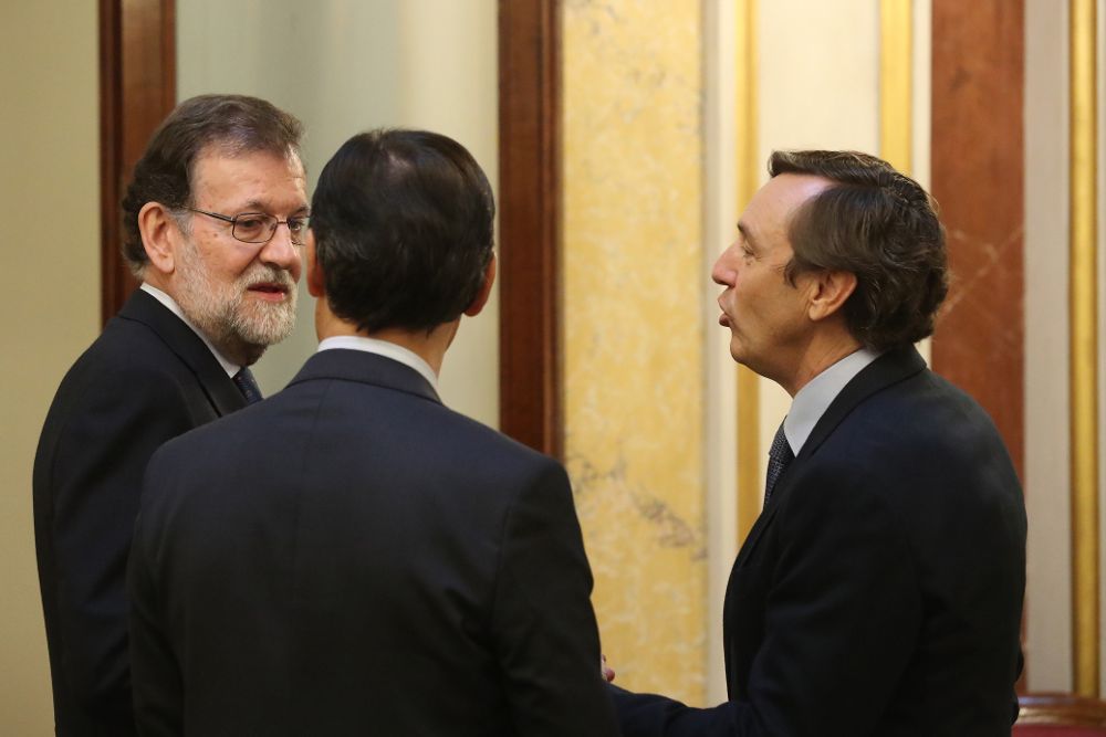 El presidente del Gobierno, Mariano Rajoy (i), conversa con el portavoz parlamentario del PP, Rafael Hernando (d), y con el coordinador general del partido, Fernando Martínez-Maíllo.