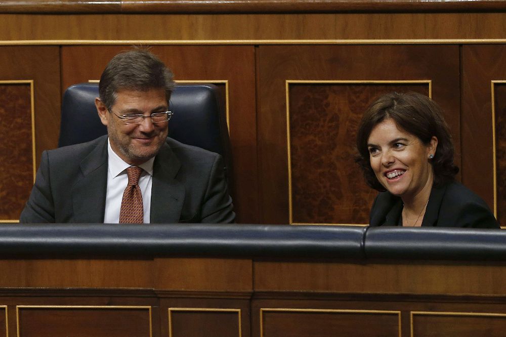 El ministro de Justicia, Rafael Catalá, junto a la vicepresidenta del Gobierno, Soraya Sáenz de Santamaría, durante el debate en pleno del Congreso de los Diputados .