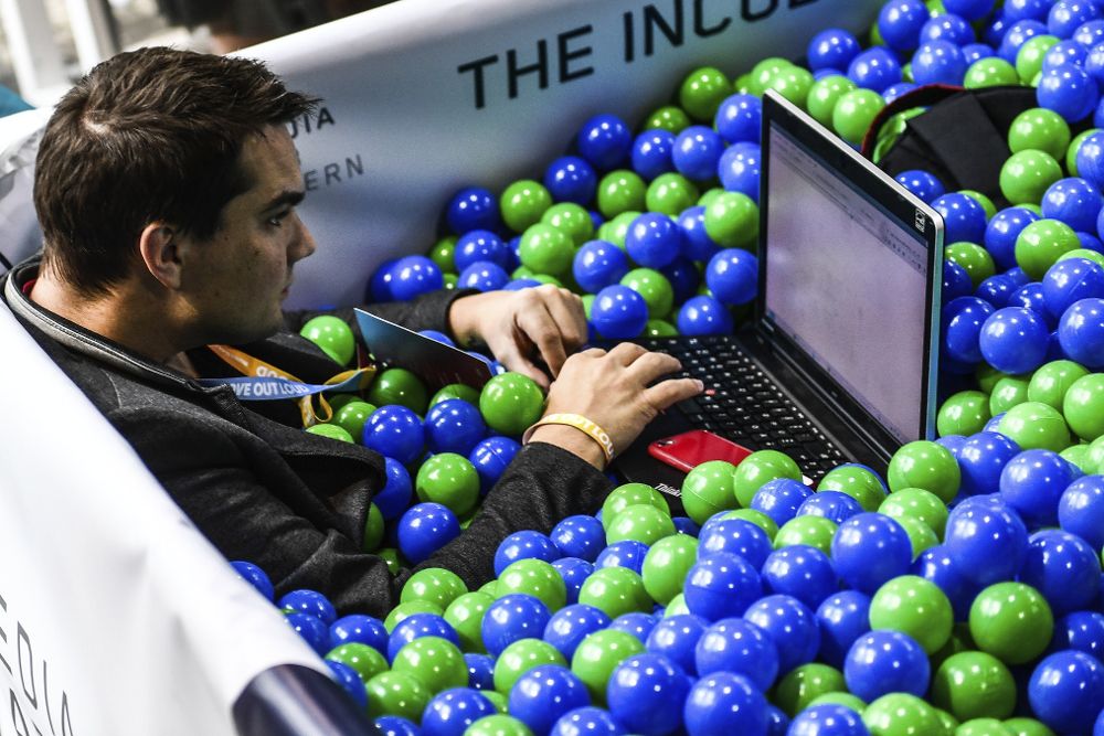 Un visitante utiliza su ordenador portátil mientras se sienta en una piscina de bolas, dentro de una "zona chill out", durante el congreso digital ''re:publica 17'' celebrado en Berlín en mayo de 2017. 
