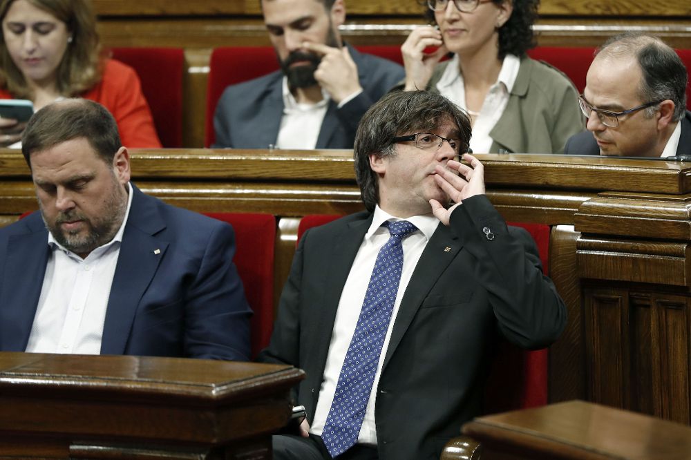 El presidente de la Generalitat, Carles Puigdemont (c), junto al vicepresidente del Govern, Oriol Junqueras (i), habla con el presidente del grupo parlamentario de Junts pel Sí, Jorid Turull.