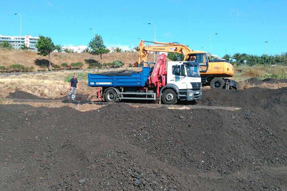 Un camión de Teideagua es cargado con los restos asfálticos de obras de rehabilitación en la autopista del norte.