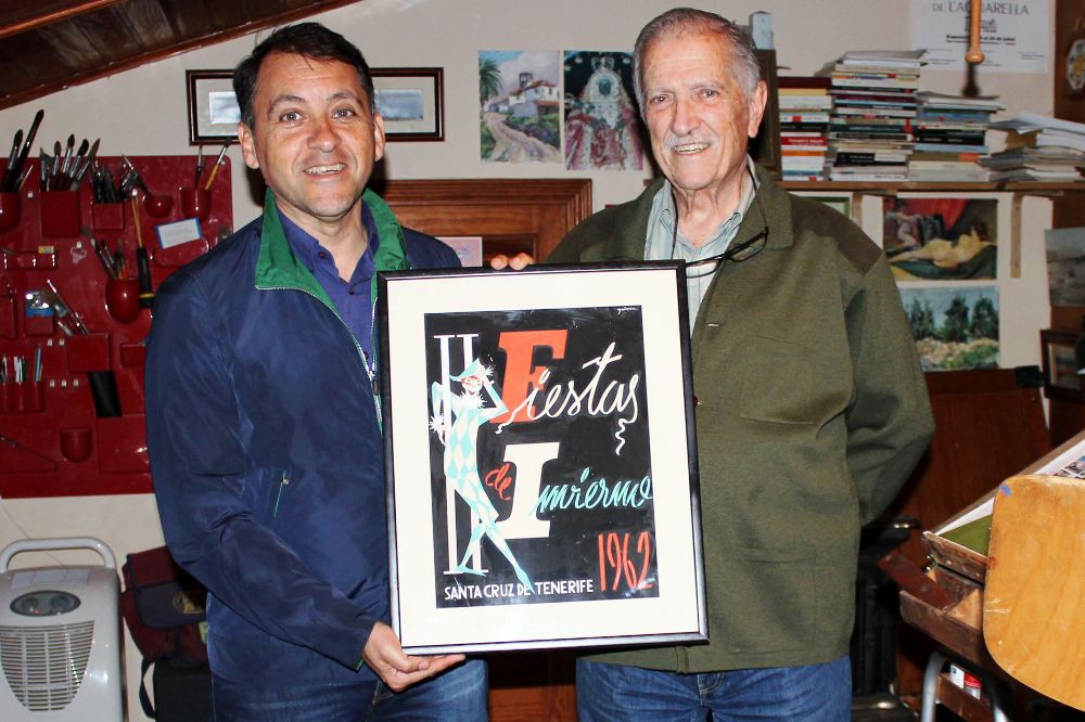 El alcalde de Santa Cruz muestra el cartel junto a su autor, el pintor Juan Galarza. 