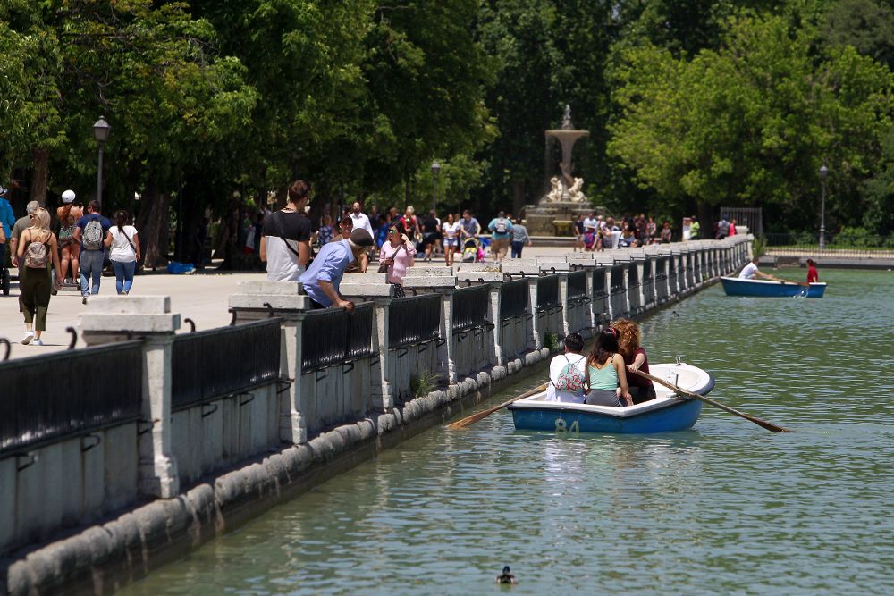 Varias personas disfrutan de una jornada soleada en el parque del Retiro de Madrid.