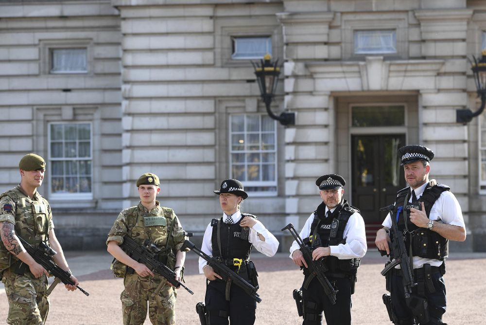 Soldados y policías británicos vigilan en los alrededores del Palacio de Buckinham, en Londres .