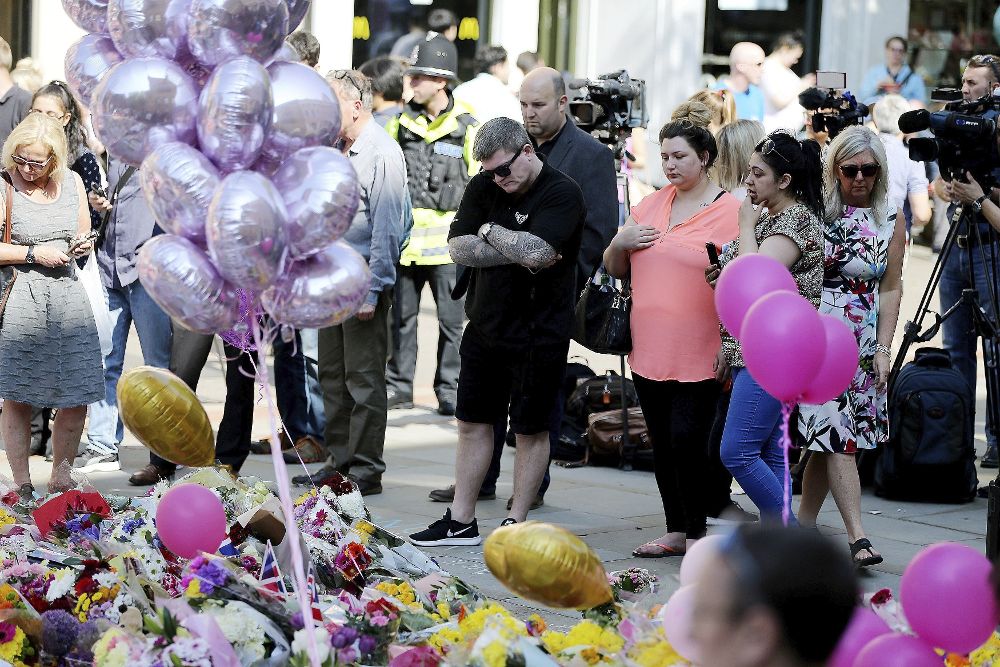 Varios ciudadanos recuerdan a las víctimas del ataque perpetrado en el Manchester Arena en la Paza de Santa Ana, en Manchester.