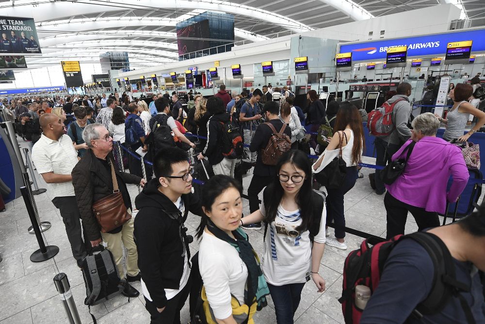 Pasajeros de la compañía británica British Airways esperan en las largas colas en el aeropuerto de Heathrow, en Londres (Reino Unido) hoy, 29 de mayo.