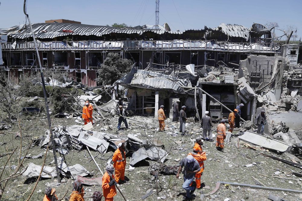 Operarios retiran los escombros junto a uno de los edificios que resultaron seriamente dañados tras el atentado suicida.