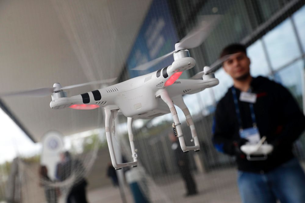 Un comercial hace volar su dron frente a unos visitantes durante la "Cube Tech Fair" en Berlín (Alemania).