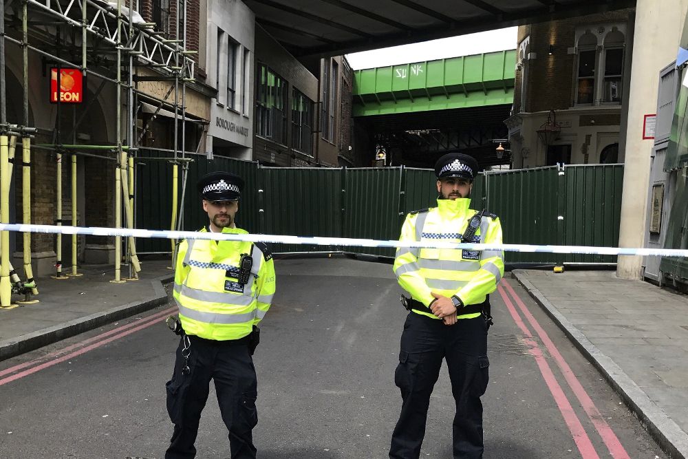 Agentes de policía británicos permanecen en guardia ante el Borough Market de Londres, Reino Unido.