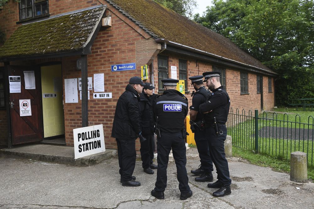 Agentes de policía hacen guardia en el colegio electoral al que acudió a votar la primera ministra británica, la conservadora Theresa May, en Sonning, en el condado inglés de Berkshire.