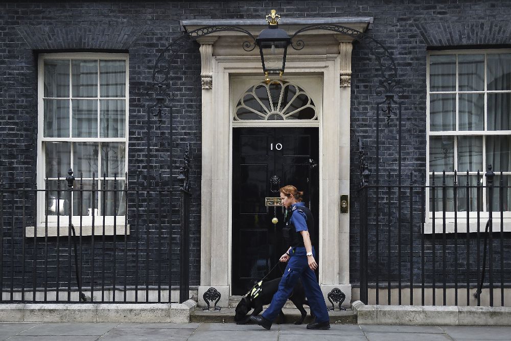 Una policía y su perro pasan ante el nº 10 de Downing Street.