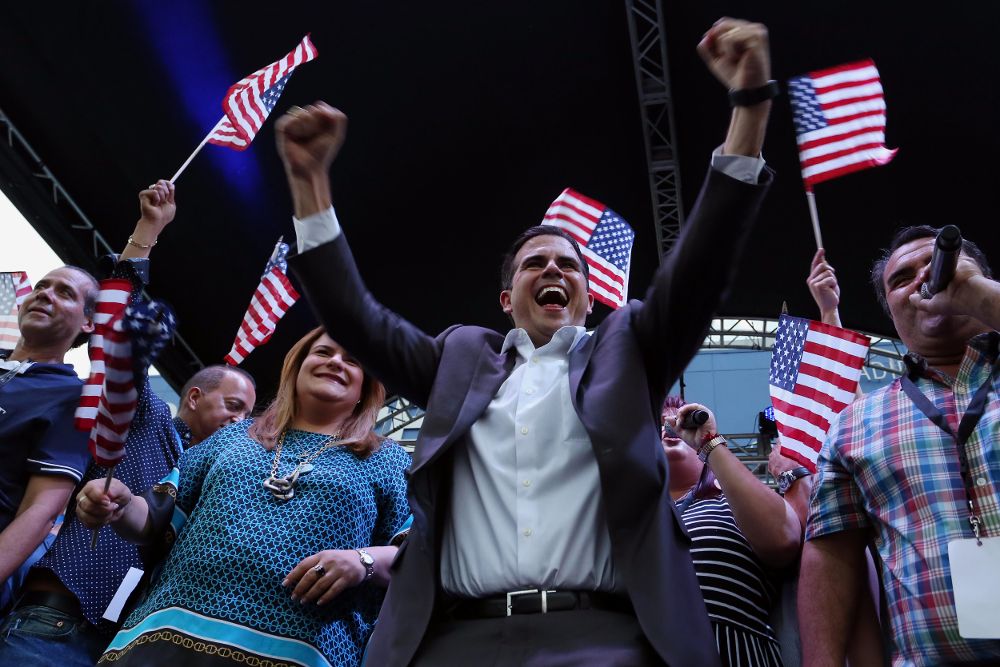 El gobernador de Puerto Rico, Ricardo Rosselló (c) y la comisionada residente en Washington Jennifer González (3i) celebran el resultado del plebiscito en la sede del Partido Nuevo Progresista, ayer, domingo.