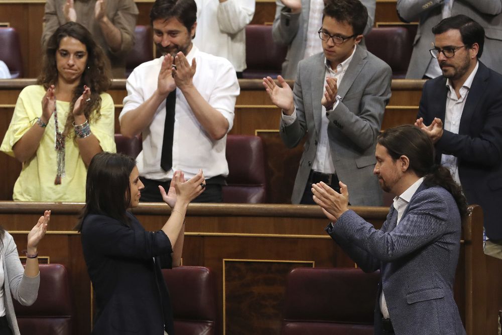 Irene Montero, es aplaudida por Pablo Iglesias (d, abajo), y los diputados Alberto Garzón, Íñigo Errejón, Rafael Mayoral (d-i, arriba), tras su intervención.