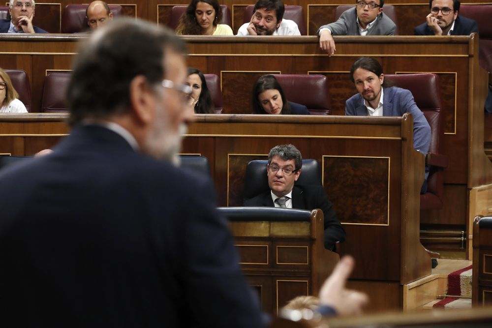 El presidente del Gobierno, Mariano Rajoy (de espaldas), durante una de sus intervenciones en el debate, hoy en el pleno del Congreso, de la moción de censura que Unidos Podemos ha presentado contra él.