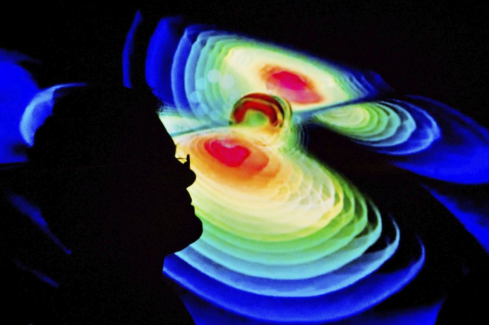 2016) en la que un científico observa una representación de las ondas gravitacionales.