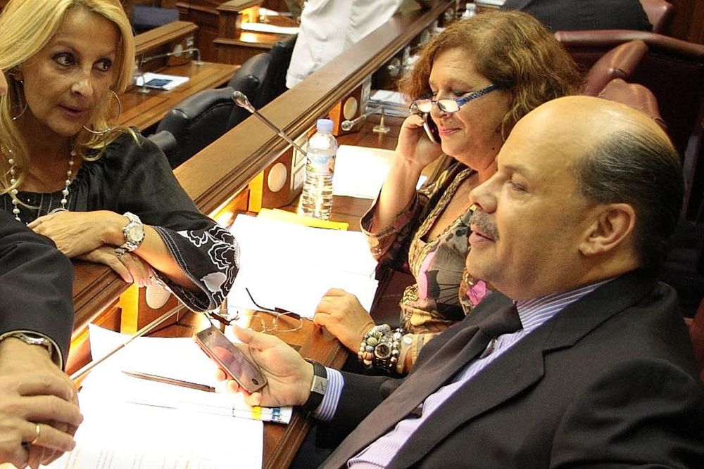 María Australia Navarro (i) habla con el nacionalista José Miguel Barragán en presencia de su compañera Marisa Zamora en el Parlamento.