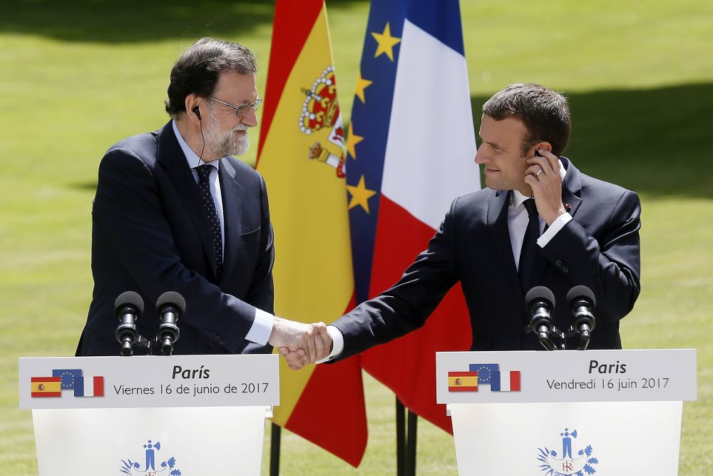 El presidente francés, Emmanuel Macron (d), estrecha la mano del jefe del Gobierno español, Mariano Rajoy, durante una rueda de prensa tras su reunión en los jardines del palacio del Elíseo en París.