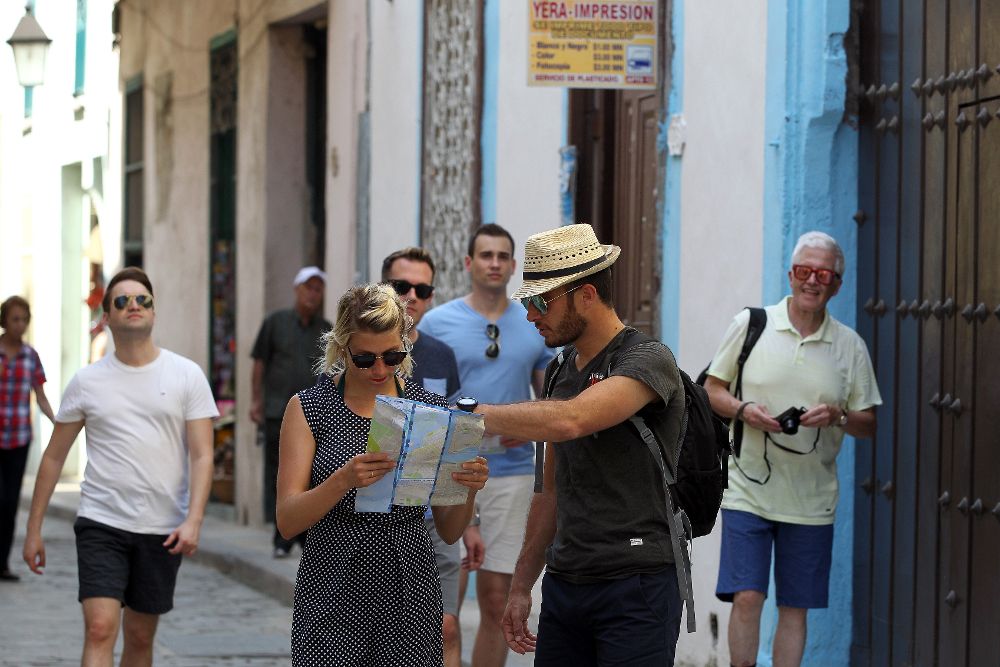 Turistas caminan por el centro histórico hoy, viernes, en La Habana. Cuba está atenta hoy a la transmisión de los principales medios de comunicación de la isla, todos estatales, del minuto a minuto por internet del acto en Miami (EE.UU.).
