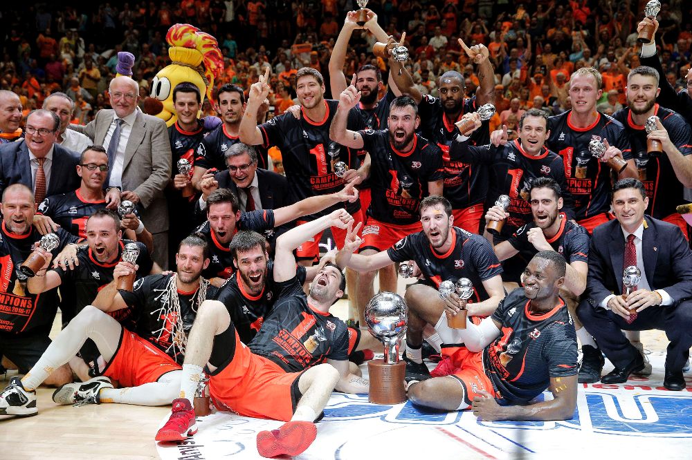 Los jugadores del Valencia Basket celebran con la copa el título de campeones de la Liga ACB tras imponerse en el cuarto partido al Real Madrid esta noche en el pabellón de la Fuente de San Luis de Valencia.