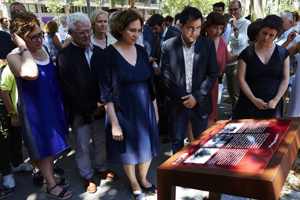 La alcaldesa de Barcelona, Ada Colau y el primer teniente de alcalde, Gerardo Pisarelo, observan la placa que recuerda a las víctimas.