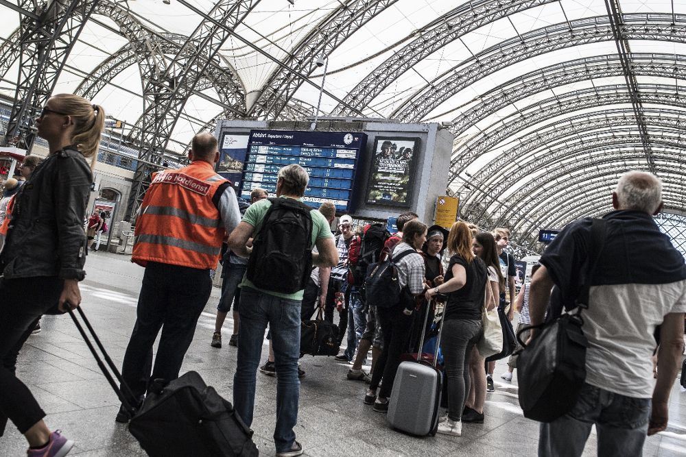 Un trabajador informa a los pasajeros sobre los retrasos en las líneas de tren en la estación de Dresde (Alemania) hoy, 19 de junio.