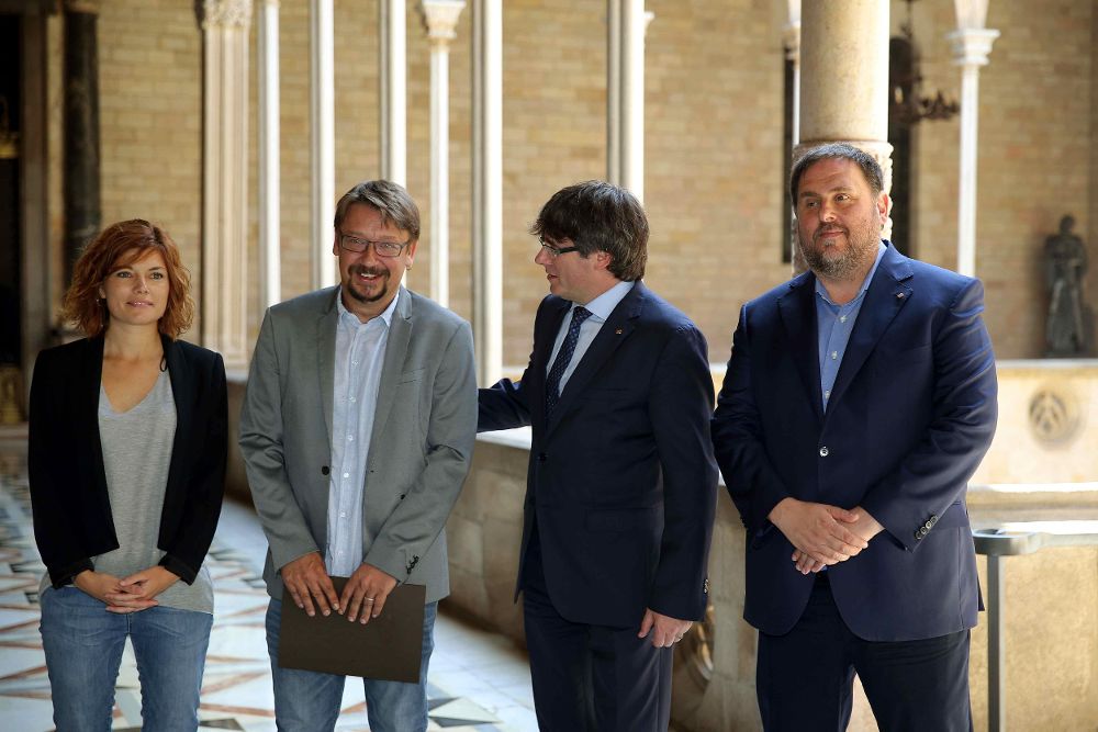 El presidente de la Generalitat, Carles Puigdemont (2d), y su vicepresidente, Oriol Junqueras (d) , con el coordinador general de Catalunya en Comú, Xavier Domènech (2i), y la portavoz y coordinadora de Comunicación de los 'comunes', Elisenda Alamany.