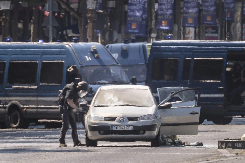 Agentes de policía galos participan en una operación en la céntrica avenida de los Campos Elíseos, donde un coche ha impactado contra un furgón de la Gendarmería francesa.
