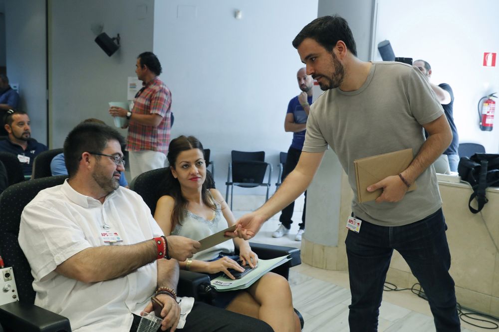 El coordinador federal de IU, Alberto Garzón, reparte invitaciones de su boda momentos antes de presentar a la asamblea federal de su formación el informe que hace balance sobre la alianza con Podemos.