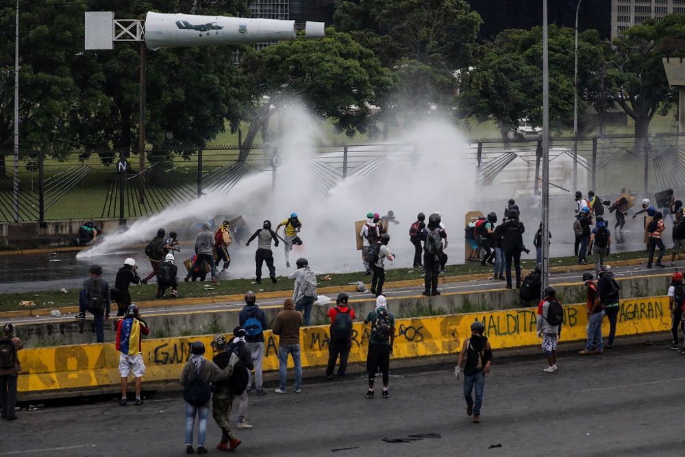 Manifestantes se enfrentan con las fuerzas de seguridad durante una protesta, el sábado, en Caracas.