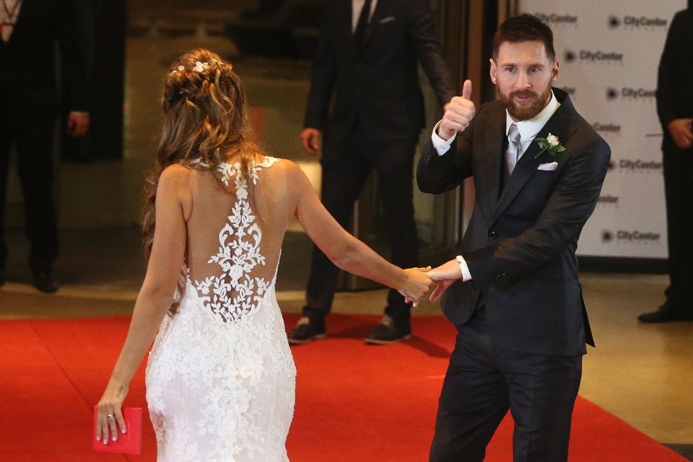 Lionel Messi (d) y su esposa, Antonella Rocuzzo, saludan tras casarse.