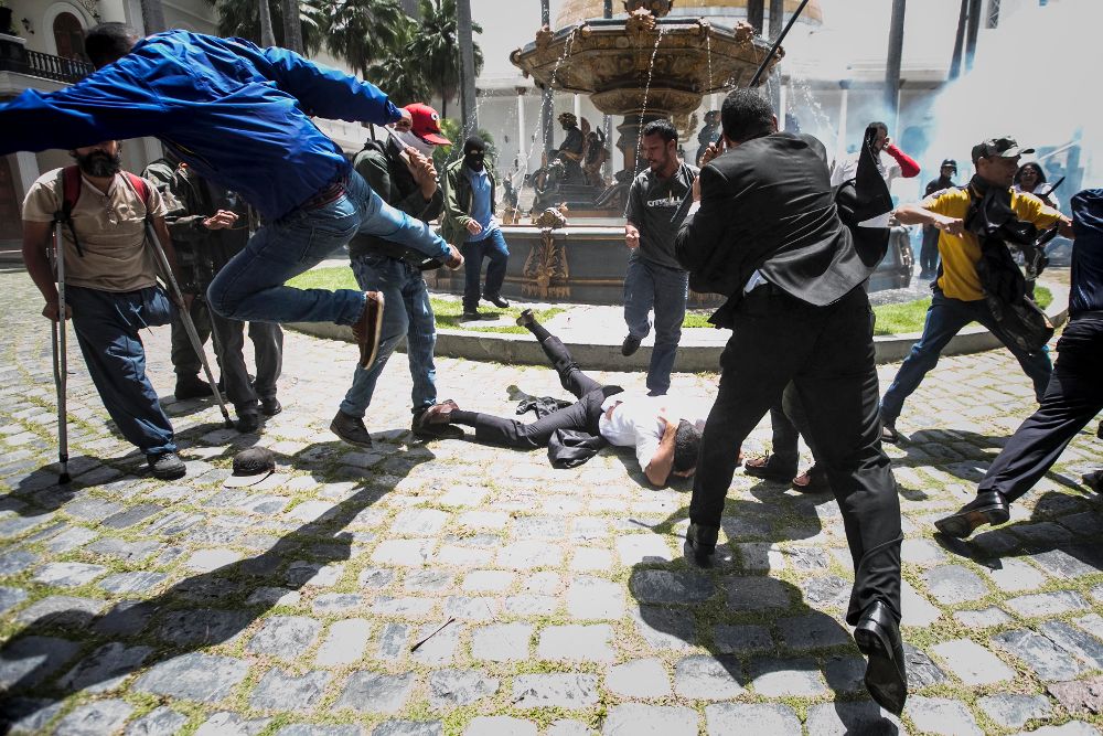 El diputado Armando Armas (c) es golpeado por manifestantes.