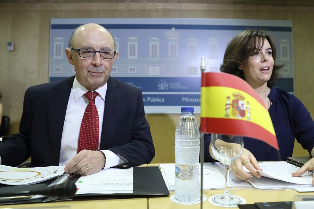El ministro de Hacienda, Cristóbal Montoro, y la vicepresidenta del Gobierno, Soraya Sáenz de Santamaría, al inicio de la reunión del Consejo de Política Fiscal y Financiera.