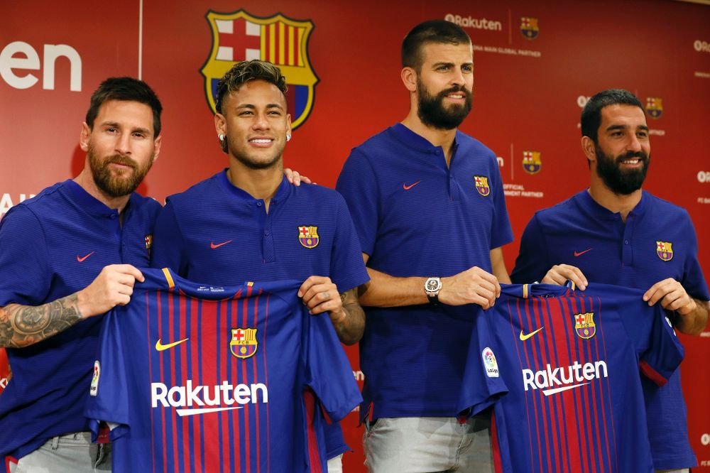 El jugador argentino del FC Barcelona Lionel Messi (i) y sus compañeros, el brasileño Neymar (2-i), Gerard Piqué (2-d), y el turco Arda Turan posan con la nueva camiseta del club.