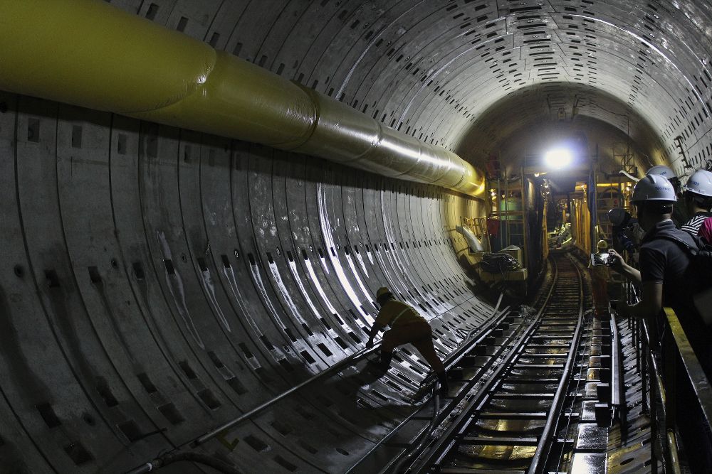 Operarios trabajan uno de los túneles tras la instalación de las placas de hormigón y raíles.