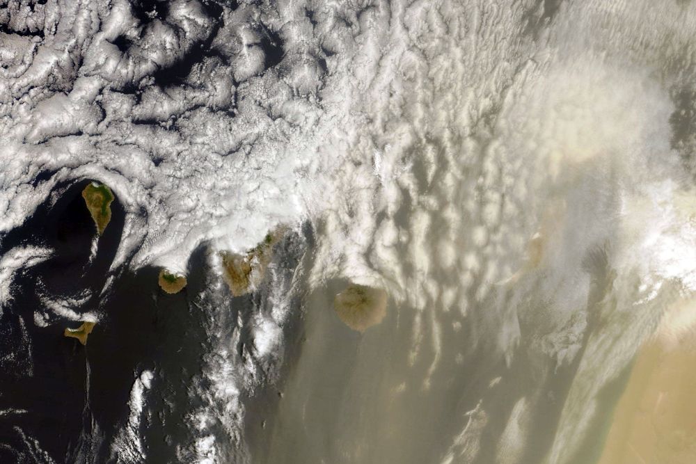 Imagen tomada ayer por el satélite Terra de la NASA a su paso por las Islas Canarias en la que se aprecia la mezcla entre la gran calima (arena y polvo en suspensión) procedente del desierto del Sáhara y la nubosidad en la zona norte de las islas.
