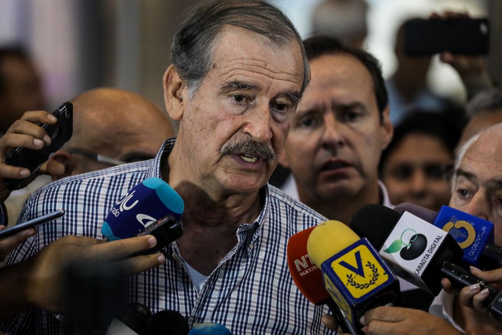 El expresidente de México Vicente Fox (c) habla con miembros de la prensa tras su llegada al aeropuerto internacional Simón Bolívar hoy, sábado.