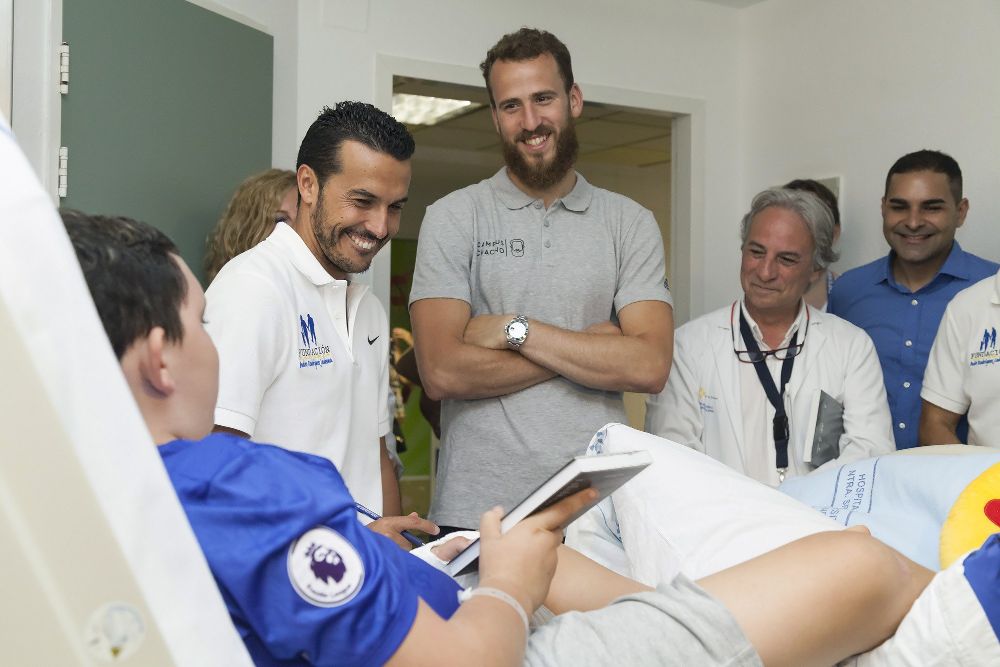 Sergio Rodríguez (c), junto al futbolista Pedro Rodríguez, cuando visitaron la Unidad de Oncología Infantil del servicio de Pediatría del Hospital de Nuestra Señora de La Candelaria, el pasado 27 de junio.