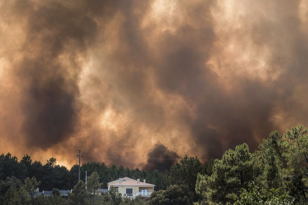Vista de las llamas y el humo cerca de una vivienda en un incendio forestal declarado en el distrito de Castelo Branco (Portugal).