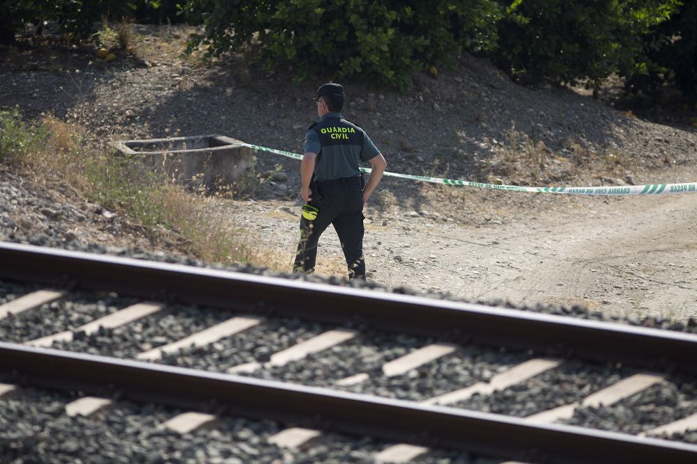 Un guardia civil inspecciona la zona acotada de la vía férrea donde un maquinista de la línea de Cercanías que une la localidad malagueña de Álora con Málaga capital detuvo el tren.