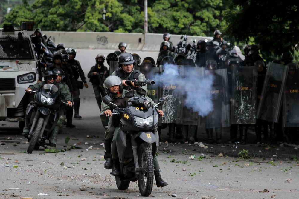 Miembros de la Guardia Nacional Bolivariana se enfrentan a un grupo de manifestantes durante una protesta antigubernamental, ayer, viernes.