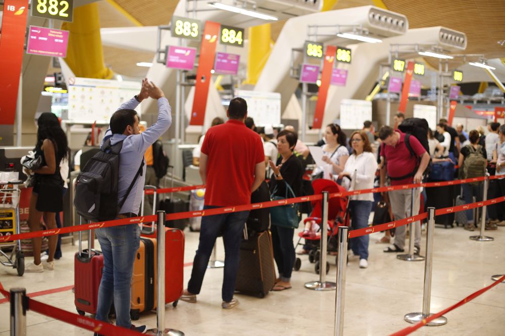 Colas de pasajeros esperan para faturar sus equipajes en la Terminal 4 del aeropuerto Madrid Barajas Adolfo Suarez.