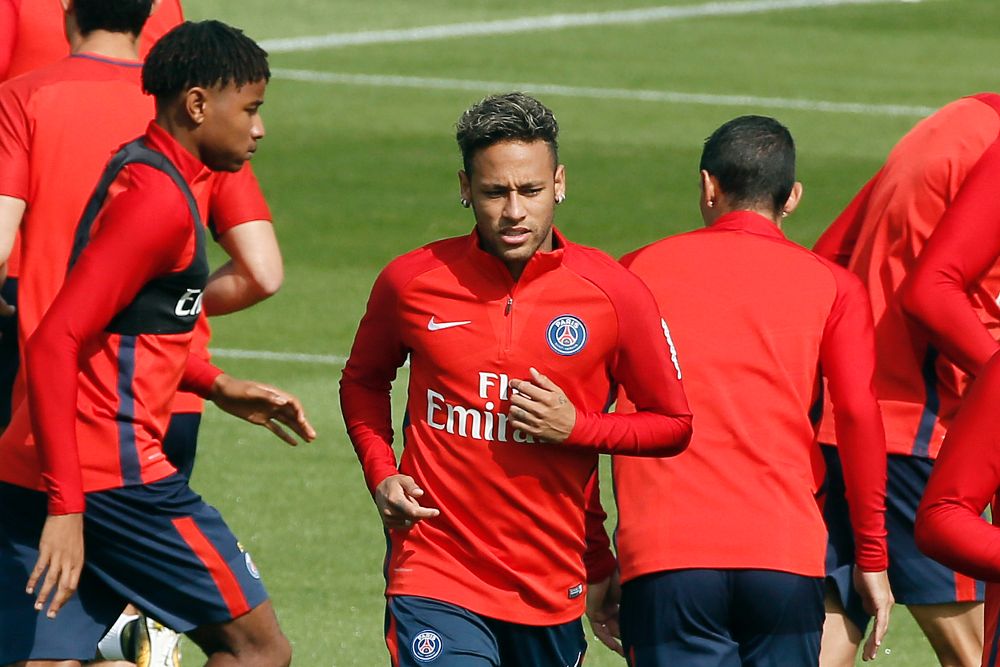 El delantero brasileño Neymar Jr (c) calienta durante una sesión de entrenamiento del París Saint-Germain.