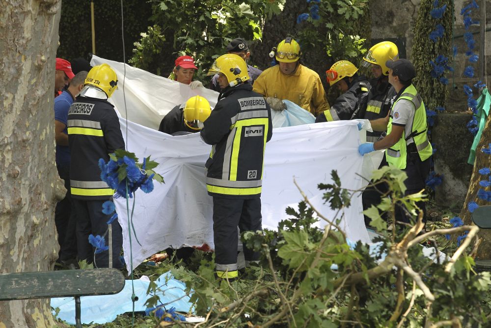 Bomberos y trabajadores de los equipos de rescate trabajan en el lugar en el que un árbol ha caído matando a 11 personas e hiriendo a 35, en Largo da Fonte, Madeira.