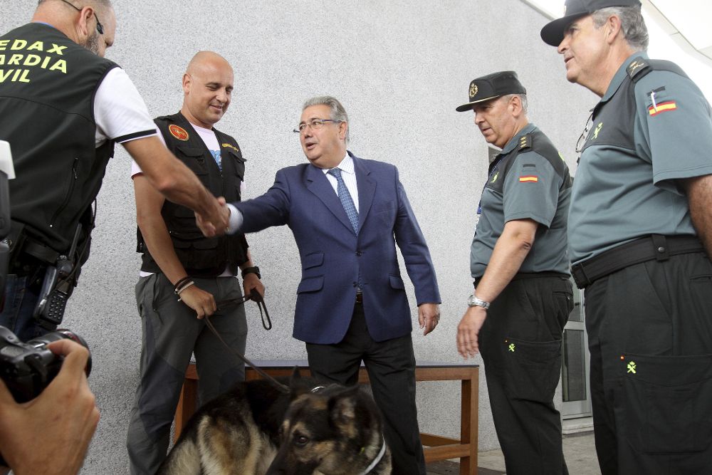 El ministro del Interior, Juan Ignacio Zoido (c) saluda a los guardias civiles y sus perros que controlan explosivos dentro del dispositivo de la Operación Paso del Estrecho.