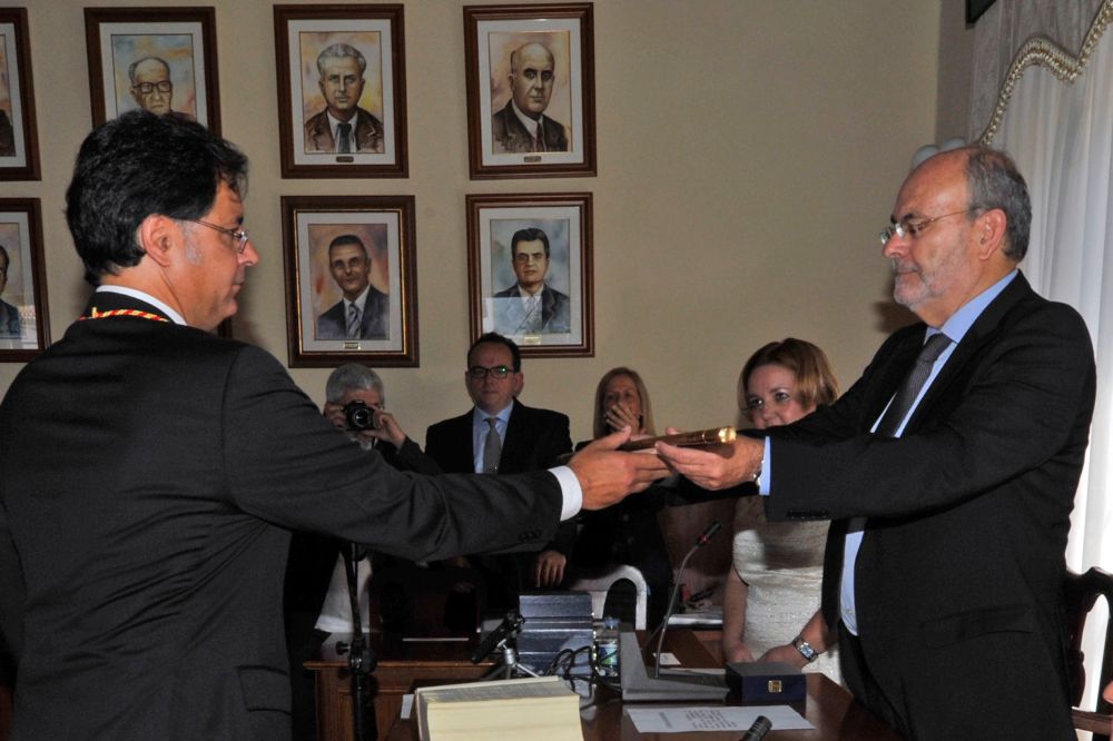 El alcalde saliente (iz) entrega la vara de mando a José Ramón León.
