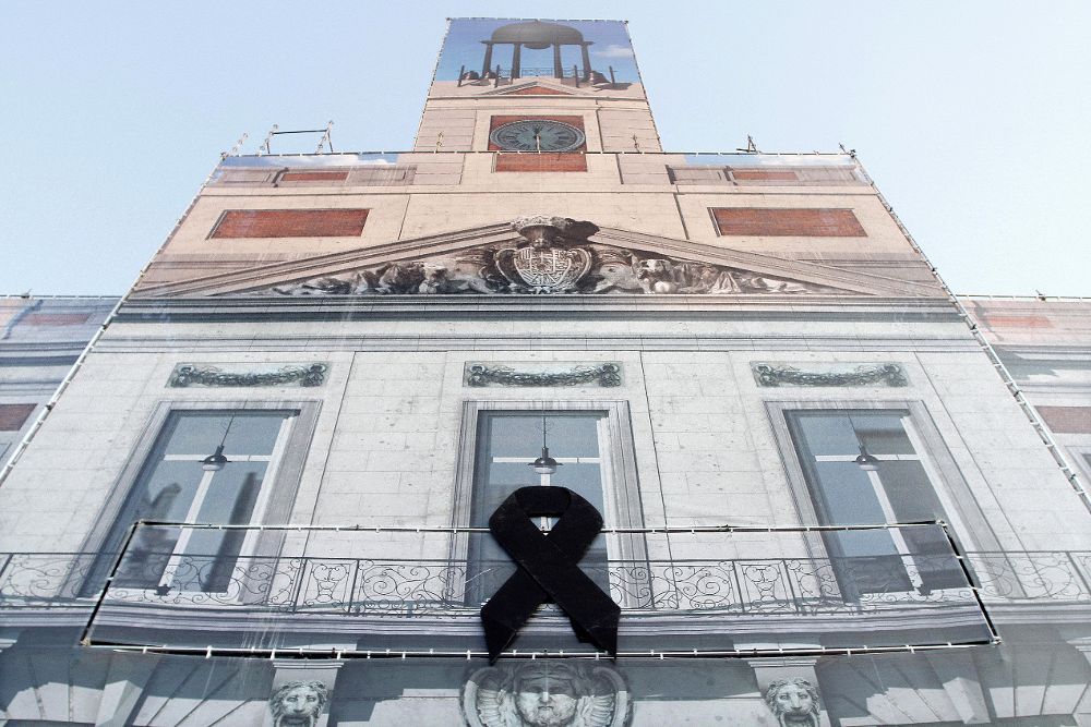 Fachada de la Real Casa de Correos, sede del Gobierno de la Comunidad de Madrid, que luce un gran crespón negro por el atentado ocurrido hoy en las ramblas de Barcelona.