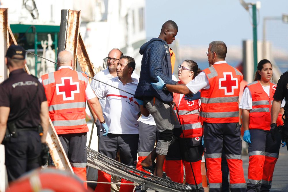 Personal de la Cruz Roja ayuda a bajar al puerto de Almería a inmigrantes.