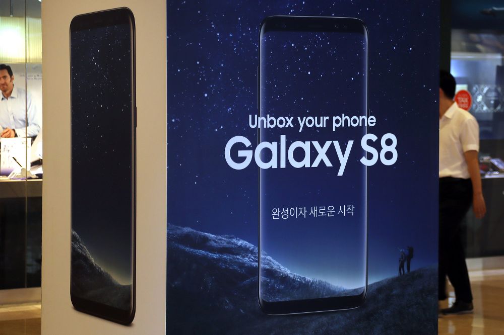 Un hombre camina detrás de un anuncio promocional en la sede de Samsung Electronics Co. en Seúl, Corea del Sur.