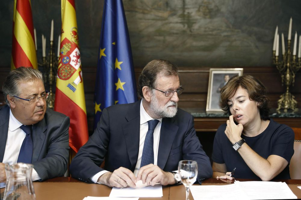 El presidente del Gobierno, Mariano Rajoy (c), junto al ministro del Interior, Juan Ignacio Zoido (i), y la vicepresidenta, Soraya Sáenz de Santamaría.
